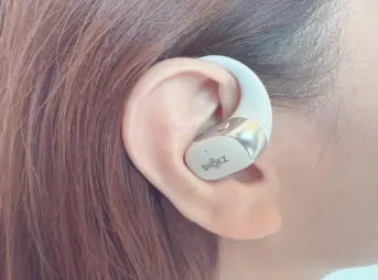 女性が右耳にShokz OpenFit 2+を装着している