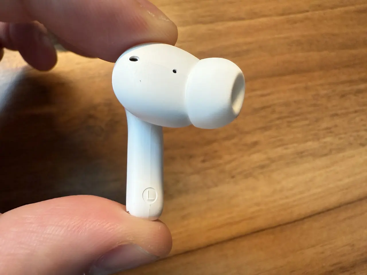 1MORE Q21のイヤホン単体を指で摘まんでいる(内側アングル)