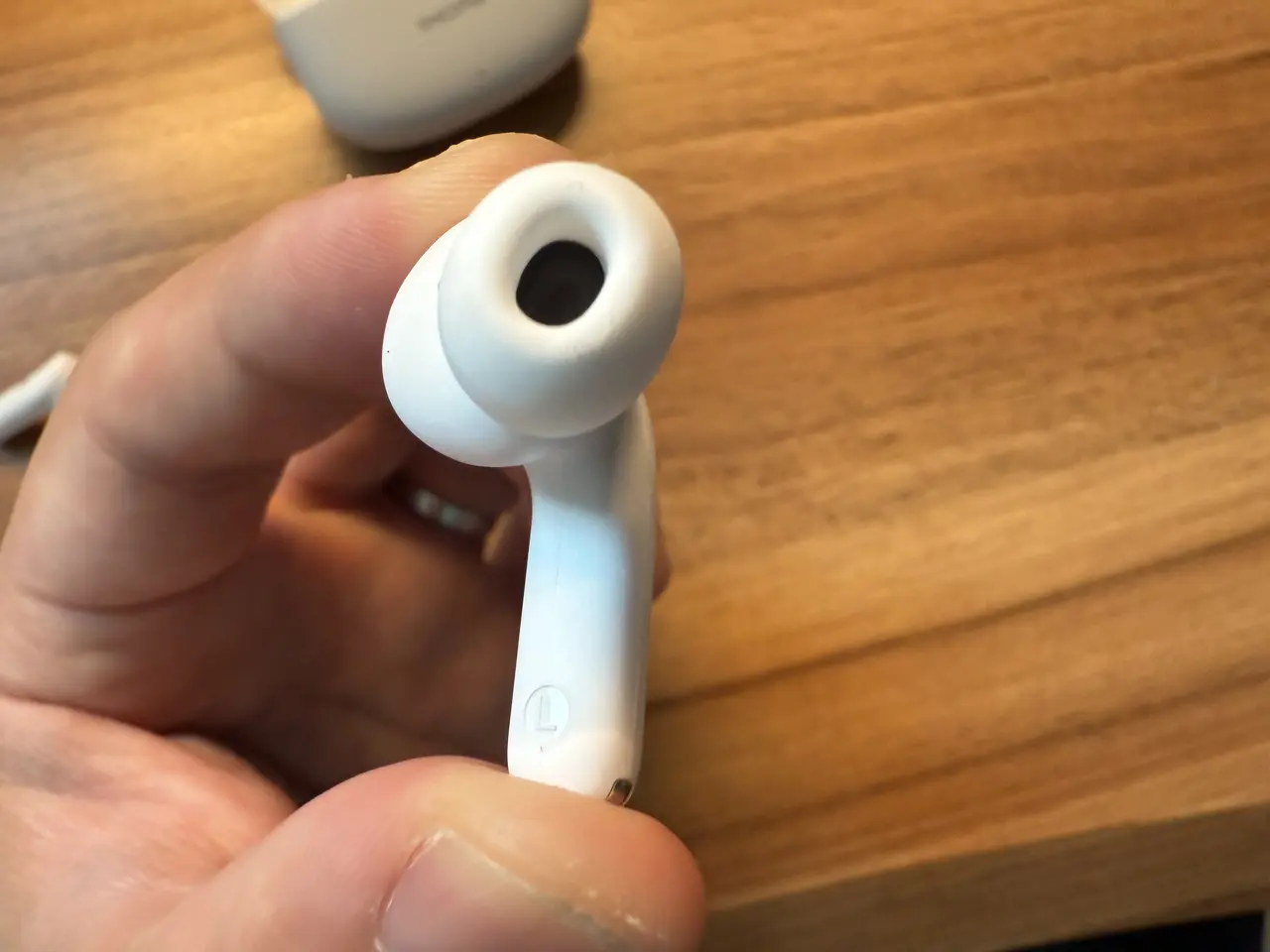 1MORE Q21のイヤホン単体を指で摘まんでいる(スピーカー穴側アングル)