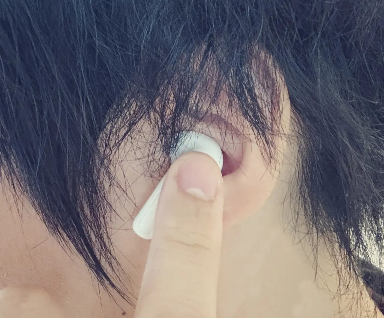 1MORE Q21を装着した左耳をタッチしている