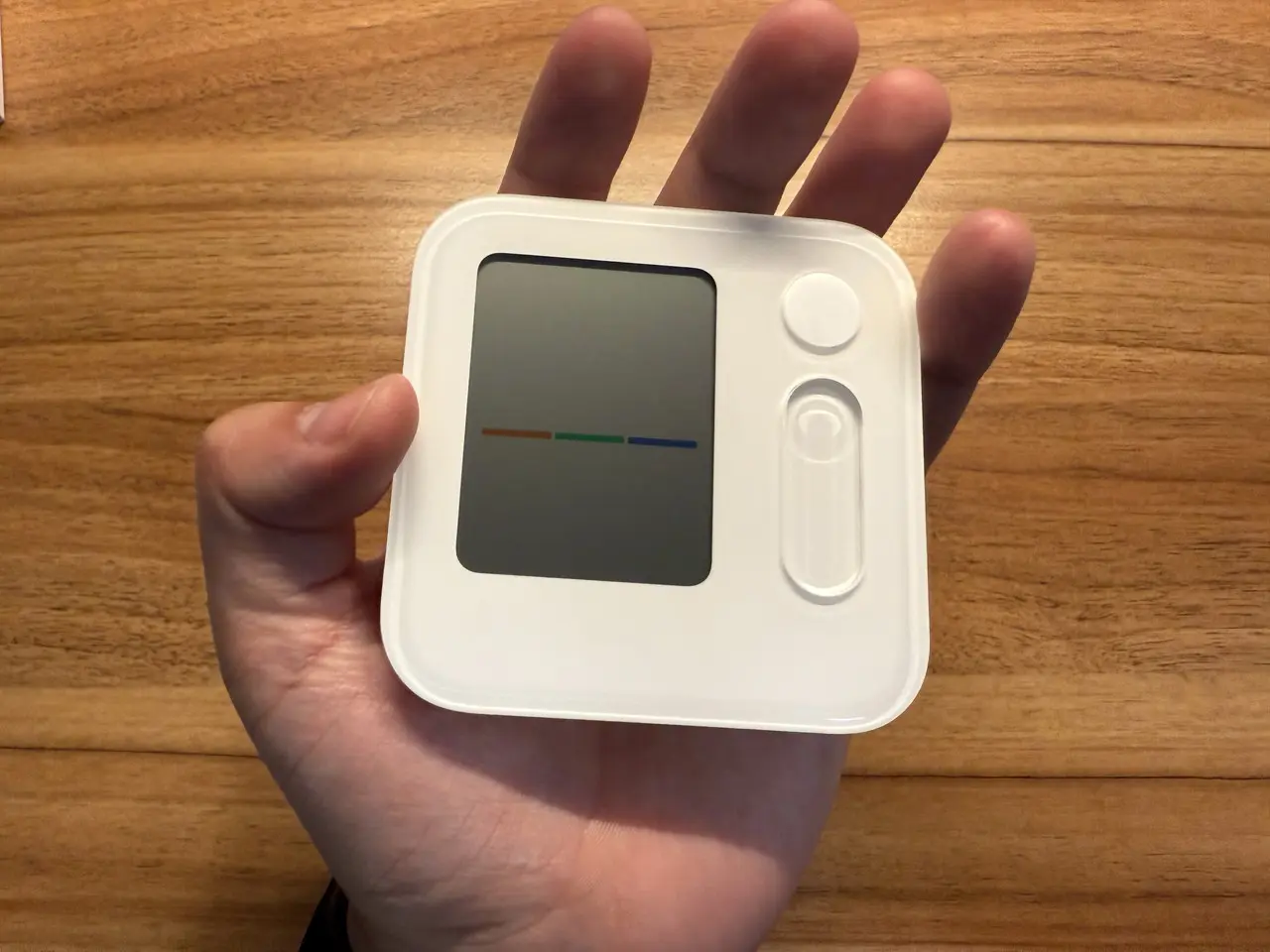 SwitchBot 温湿度管理パネルを手に持っている