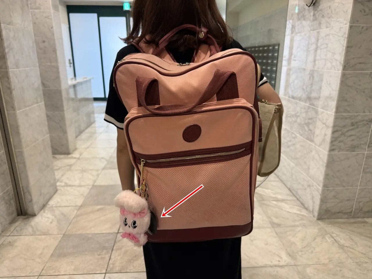 ピンクのカバンにSwitchBot 防犯ブザーを取り付けた様子