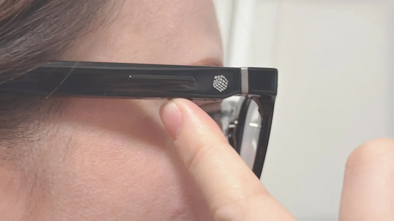 Halliday AIグラスのアクションボタンを指で押している様子