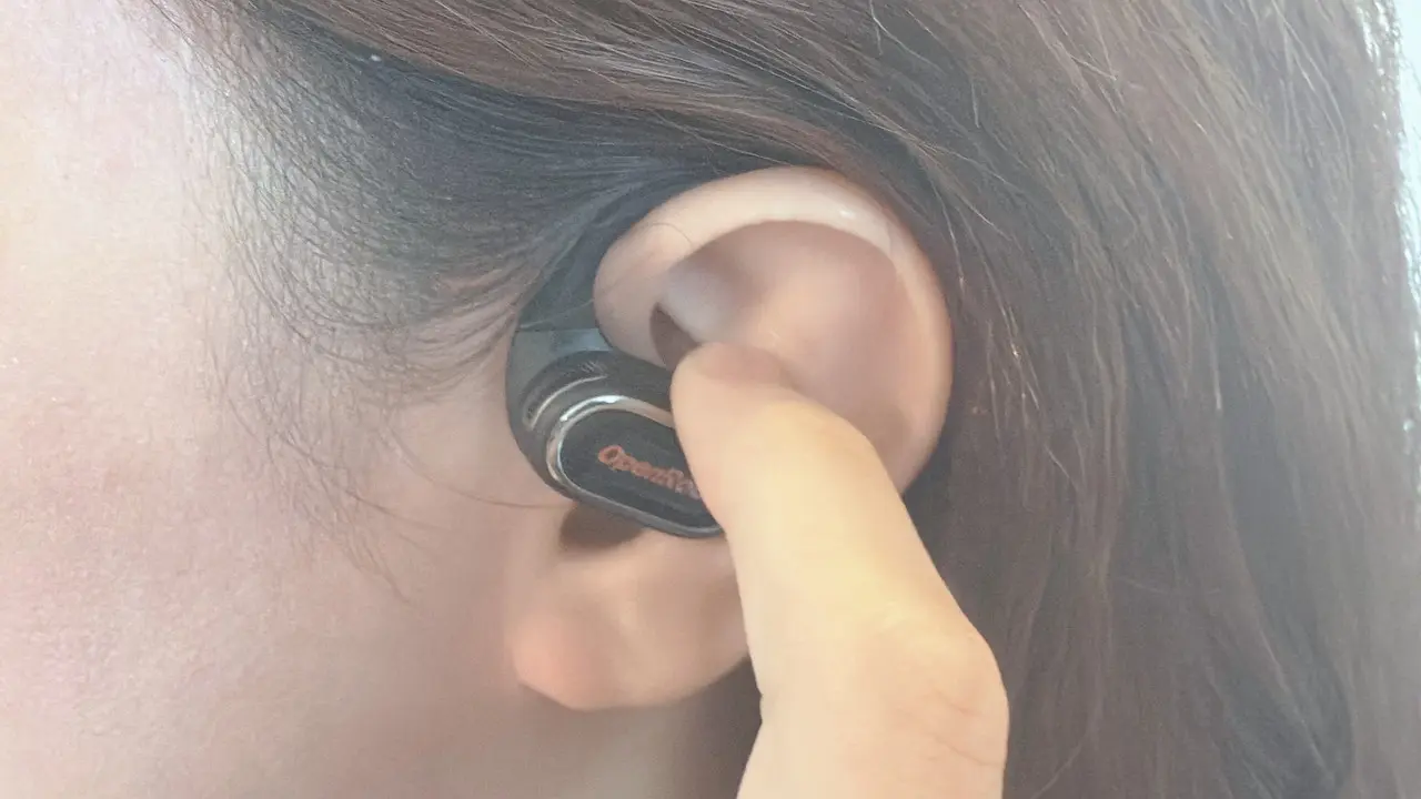 OpenRock Link 20のイヤホンのボタンを指で押している様子