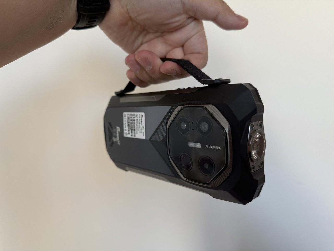 ハンドストラップホルダーを装着した状態のFOSSIBOT F113を手に持っている様子