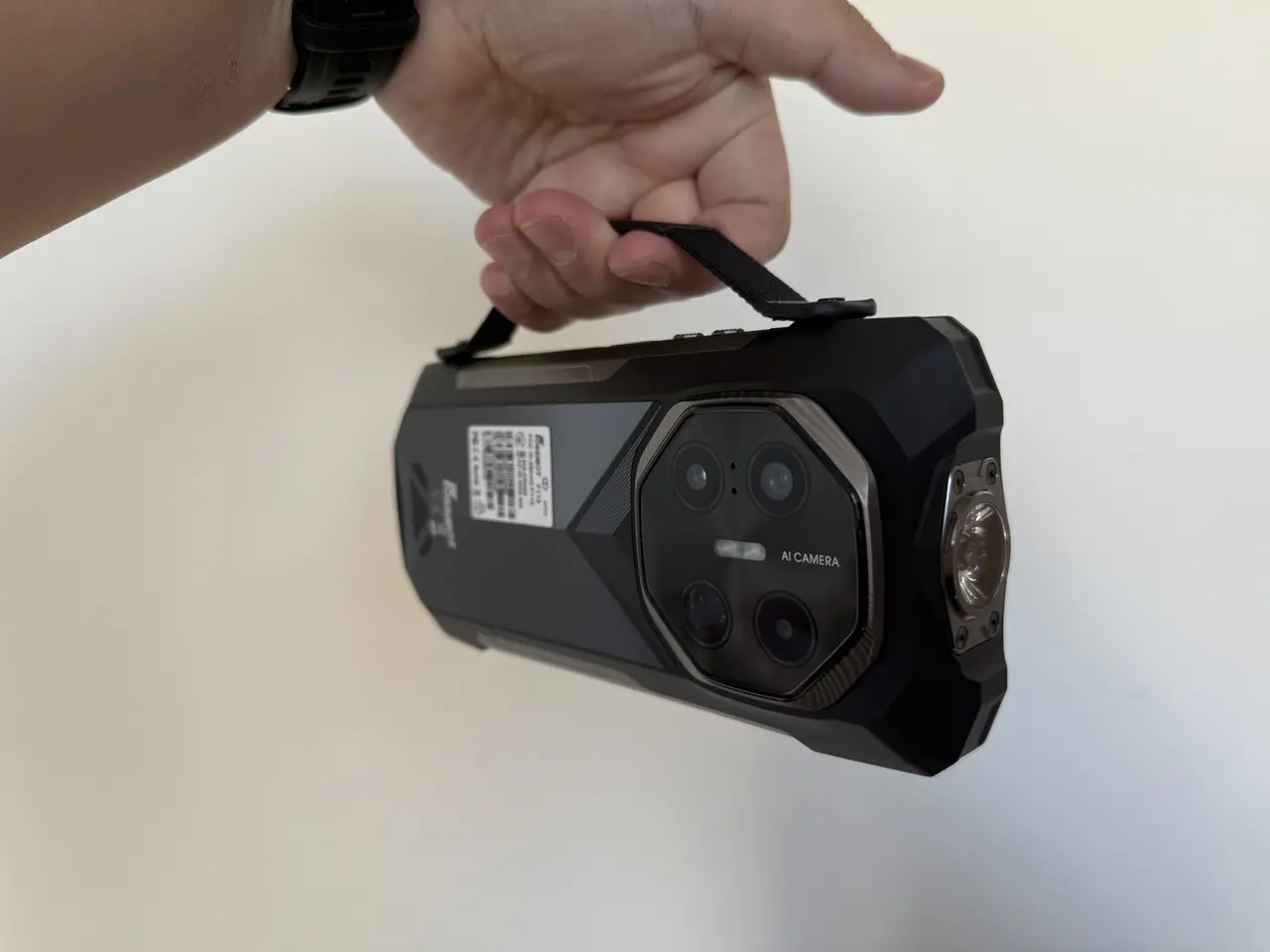 ハンドストラップホルダーを装着した状態のFOSSIBOT F113を手に持っている様子