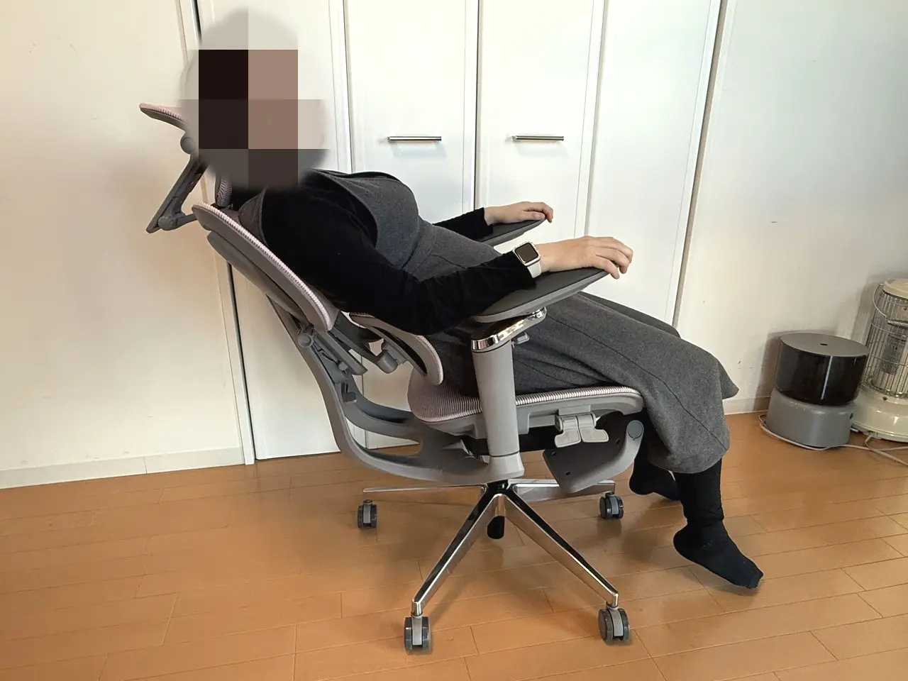 CAGUUU AXIS エルゴコアオフィスチェアに座った女性がリクライニングを後ろまで倒している様子