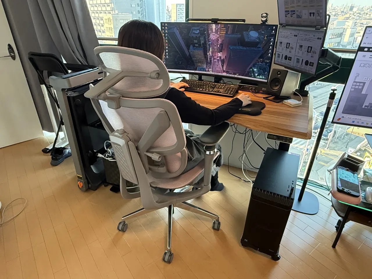 CAGUUU AXIS エルゴコアオフィスチェアに座って作業デスクに向かう女性