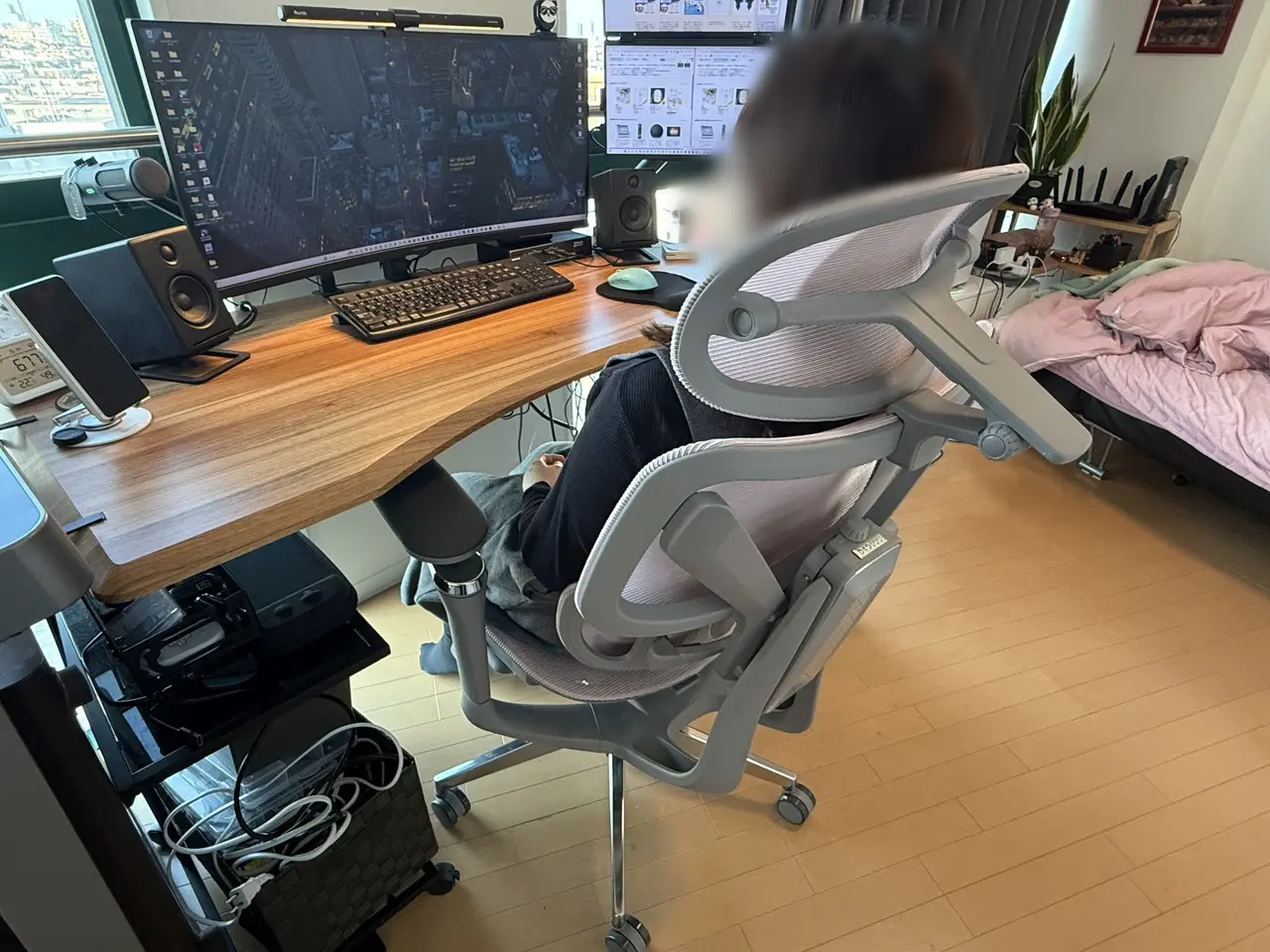 CAGUUU AXIS エルゴコアオフィスチェアに座って作業デスクに向かう女性(背面アングル)