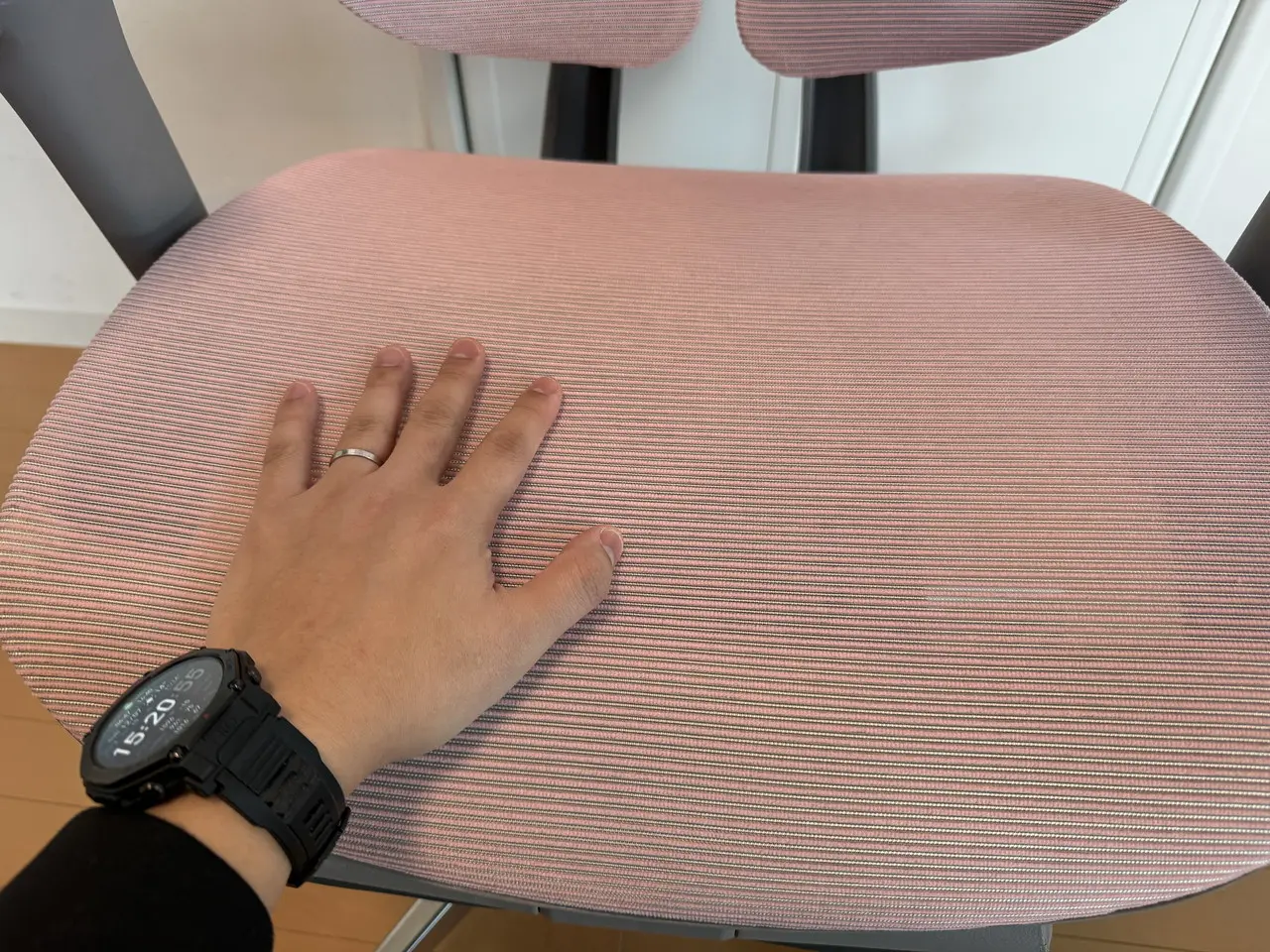 CAGUUU AXIS エルゴコアオフィスチェアの座面を手で触れている