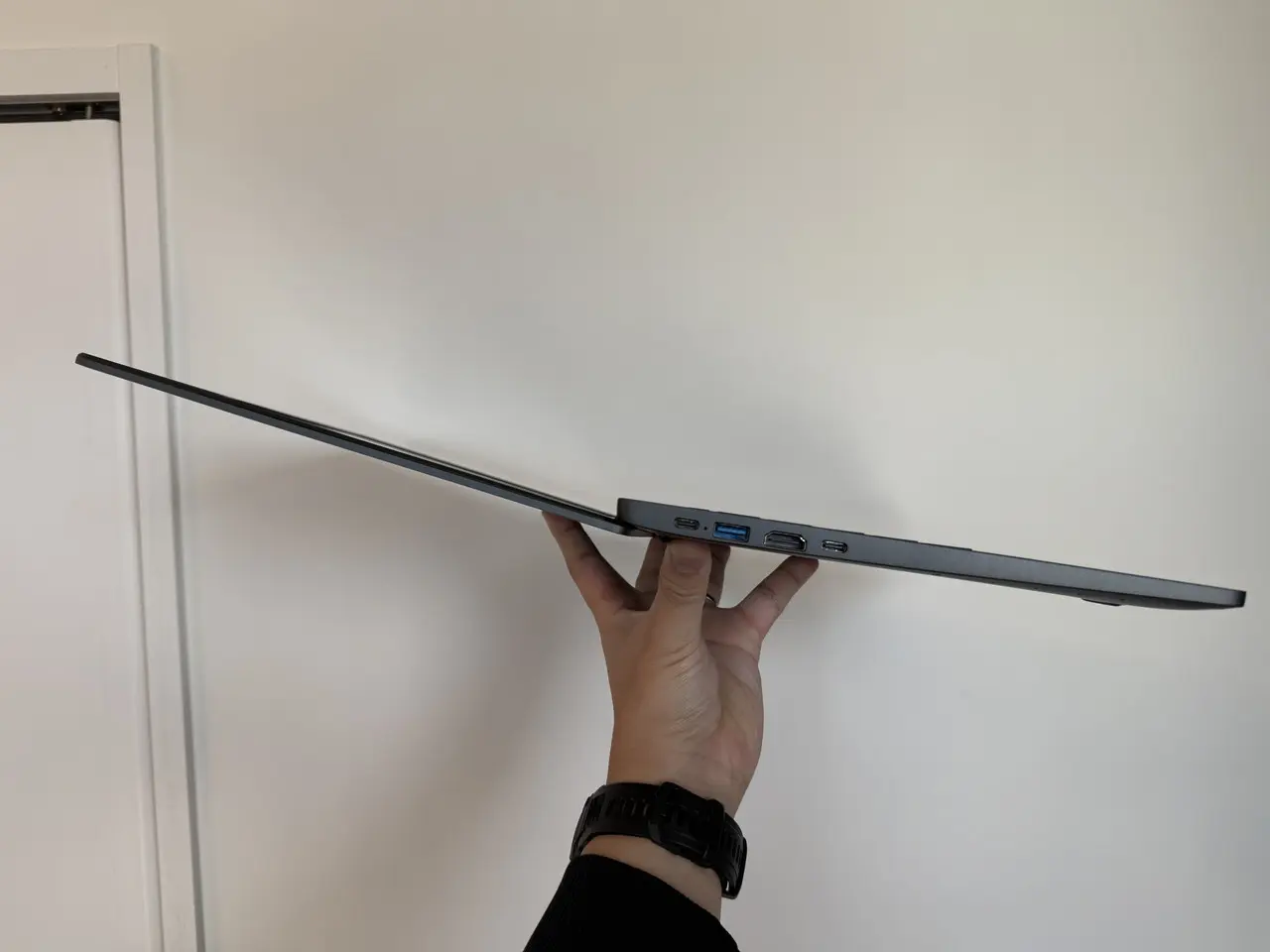 展開状態のCHUWI Corebook Xを手で持っている様子(側面アングル)