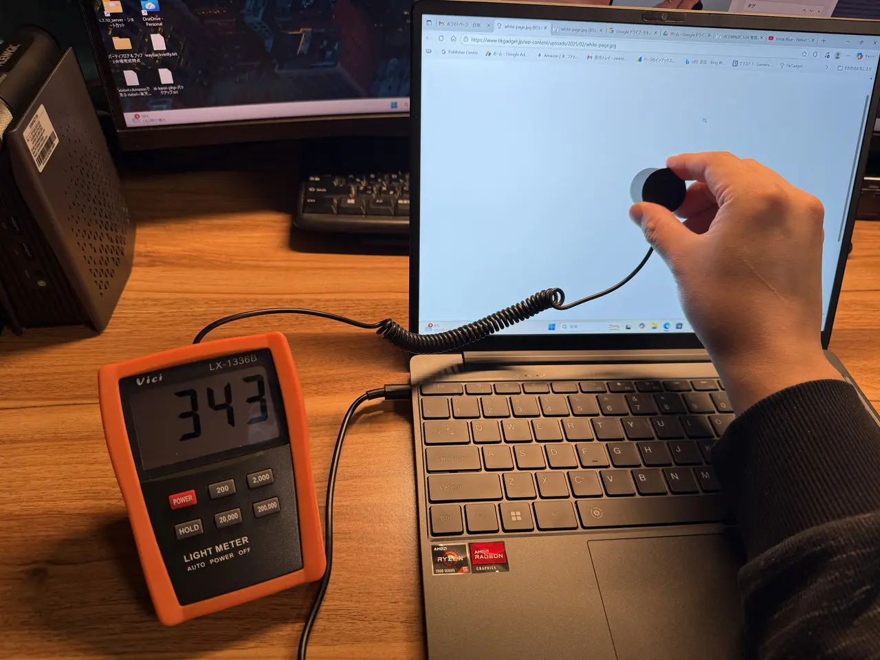 デジタルルクスメーター「Vici LX1336B」を使用して、明るさを最大に設定した際の画面中央の輝度を測定している様子