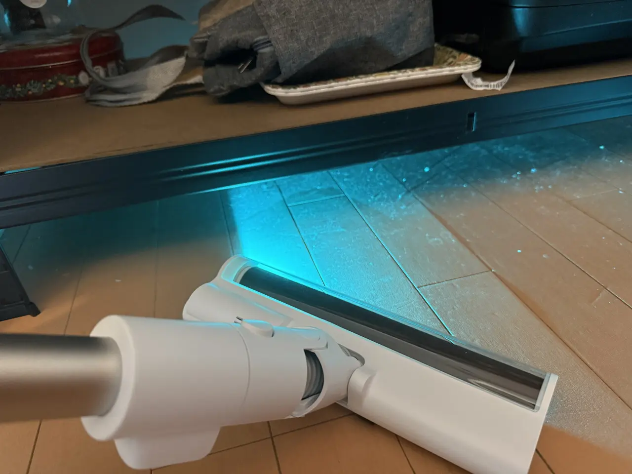 Dreame X1 Air コードレス掃除機のLEDライトで家具下のホコリを照らし出している様子