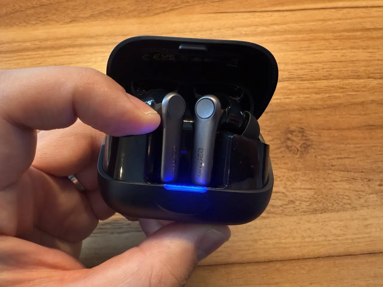 ケース下部のペアリングボタンを長押ししている様子