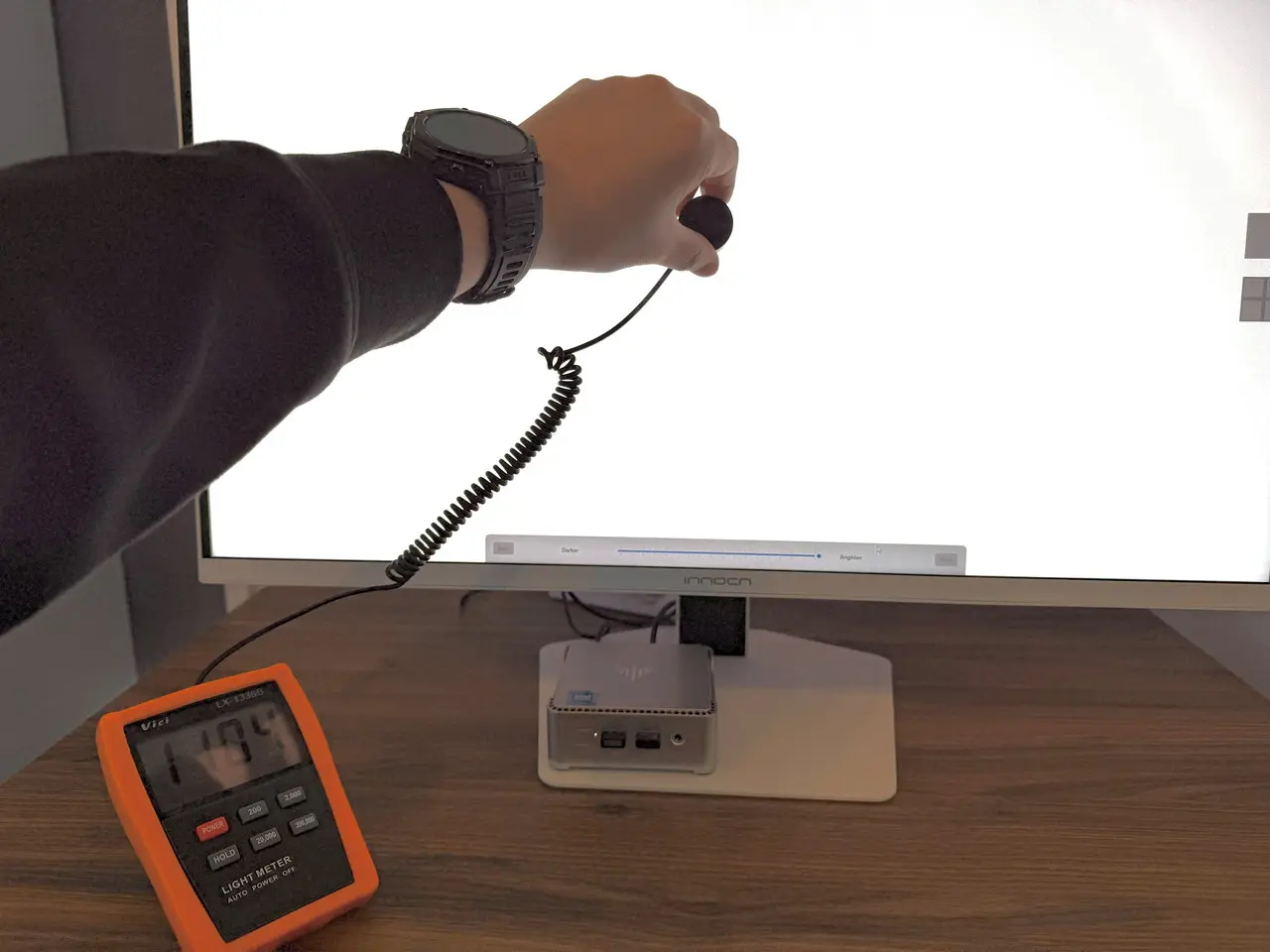 デジタルルクスメーター「Vici LX1336B」を使用して画面中央の輝度を測定している様子