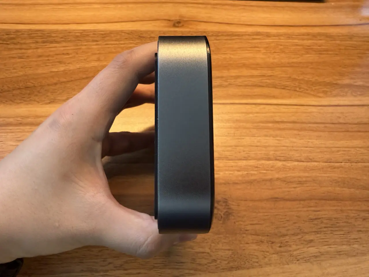 SwitchBot AIハブを手で掴んでいる様子(側面アングル)縦向き