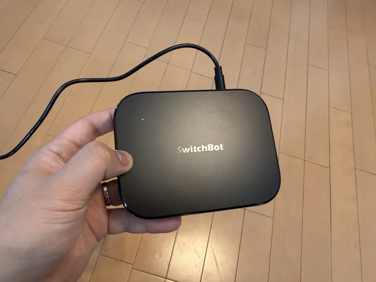接続中のSwitchBot AIハブを手に持っている様子