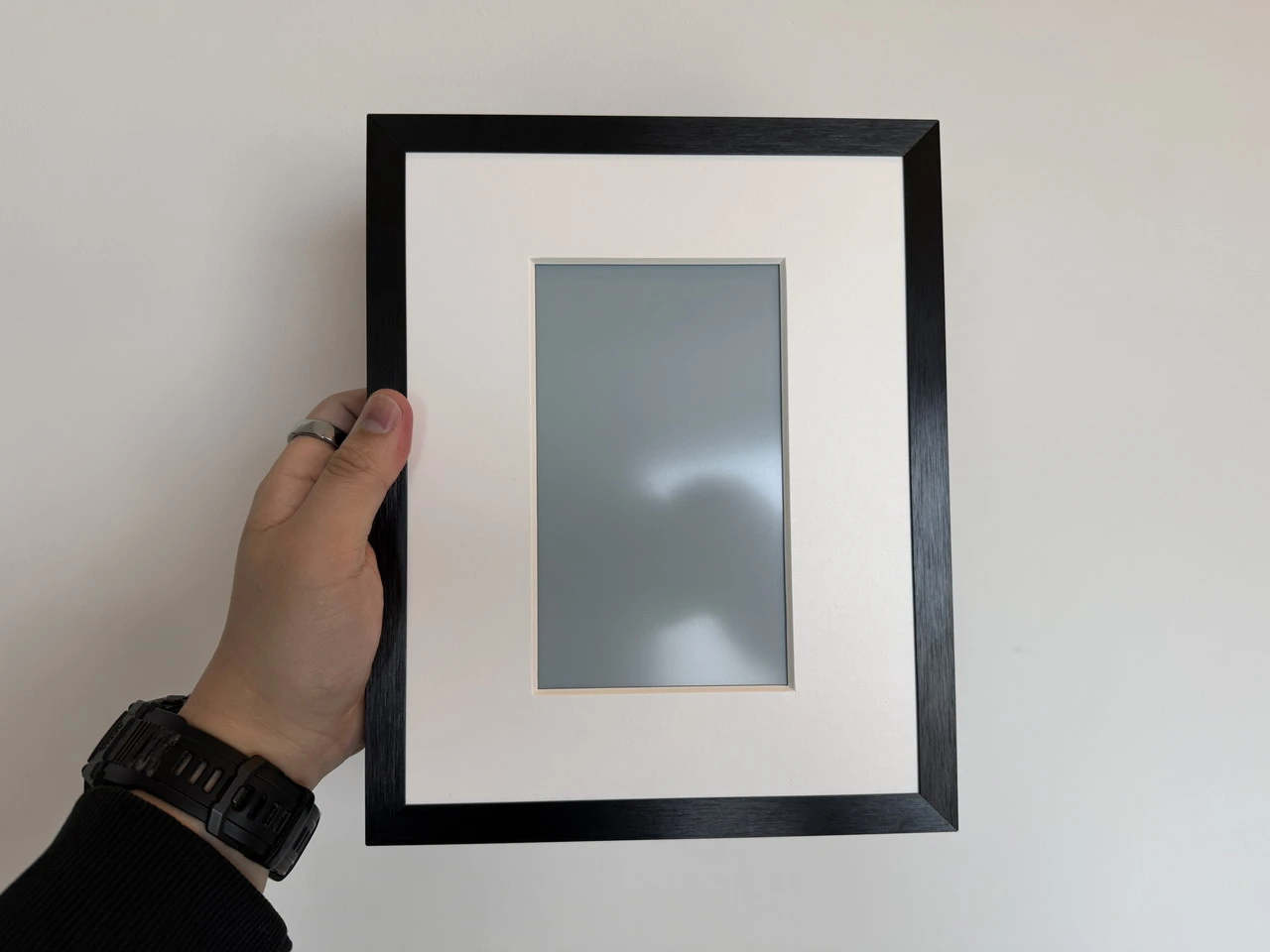 SwitchBot AIアートキャンバスを手に持っている様子(正面アングル)