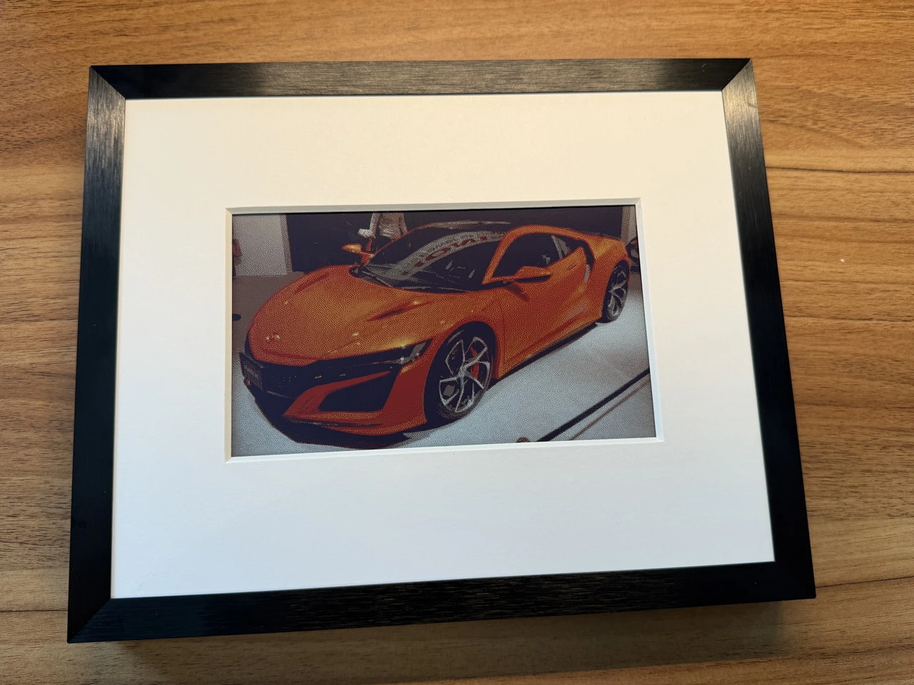 SwitchBot AIアートキャンバスにスポーツカーの写真を映し出している様子