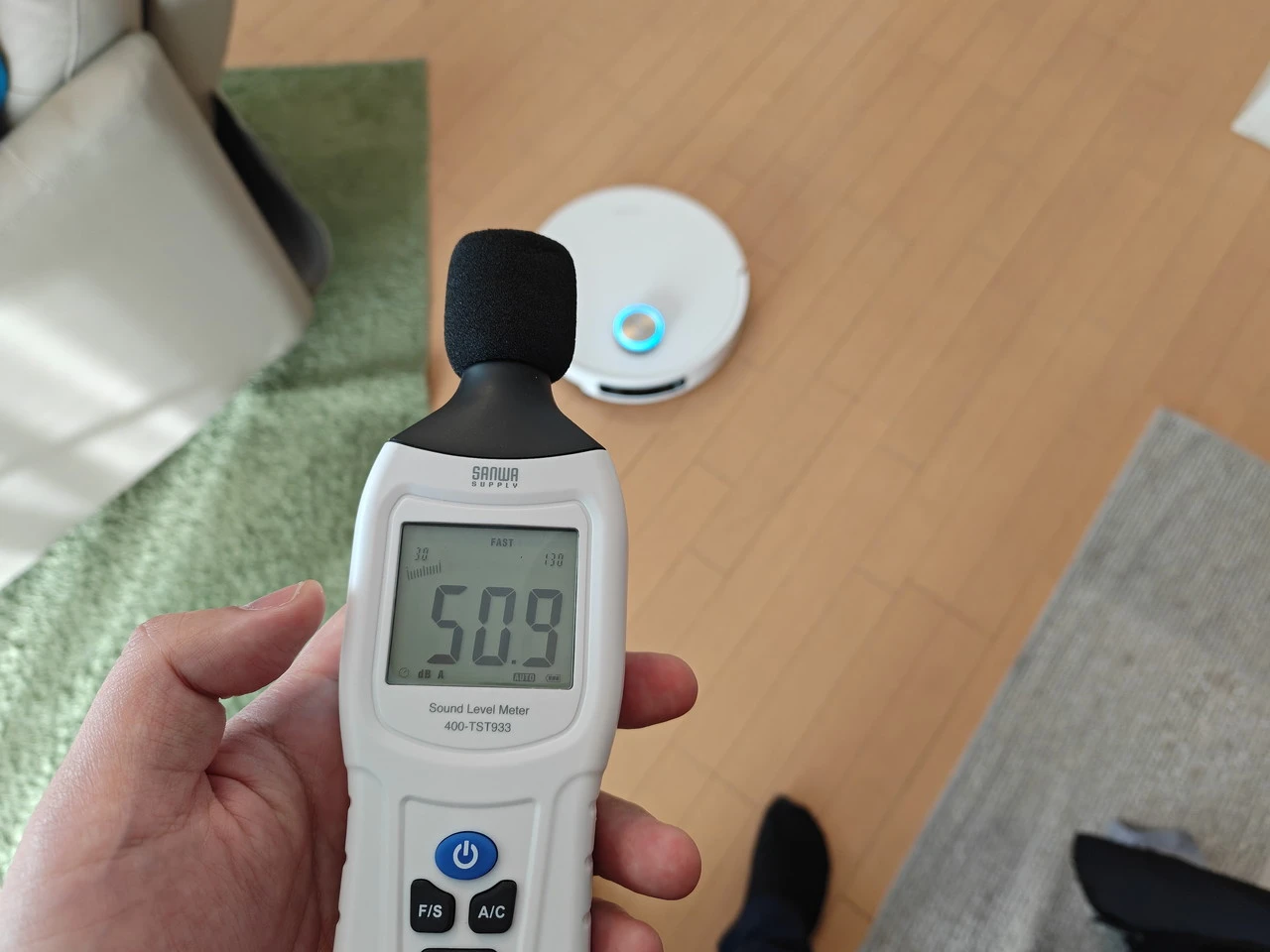 ロボットから約1mの距離で騒音計を用いて測定している様子