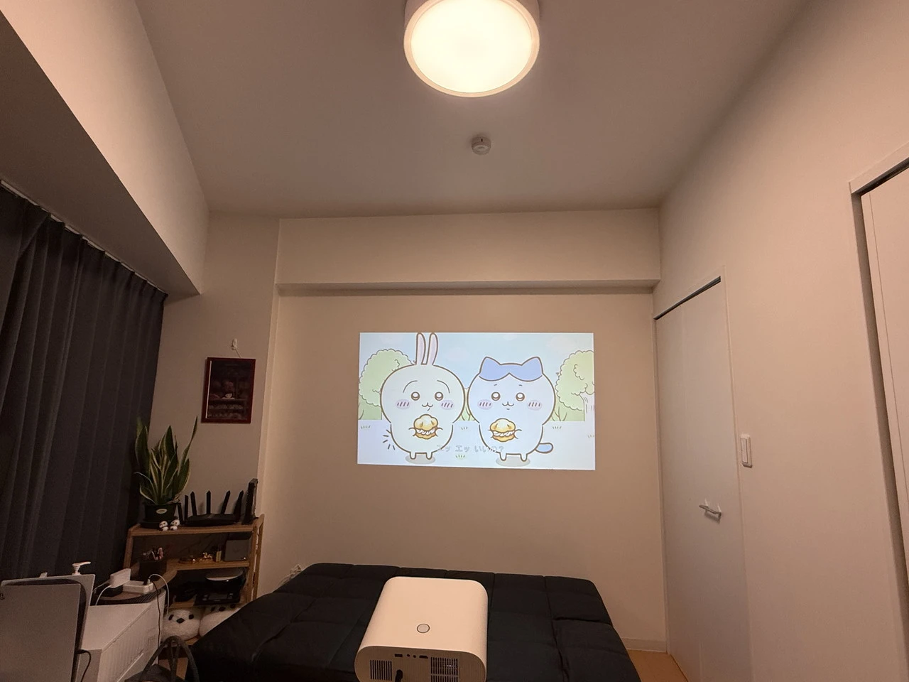 照明を点けた状態の部屋でSovboi E30Maxでアニメ映像を投影している様子(引き)