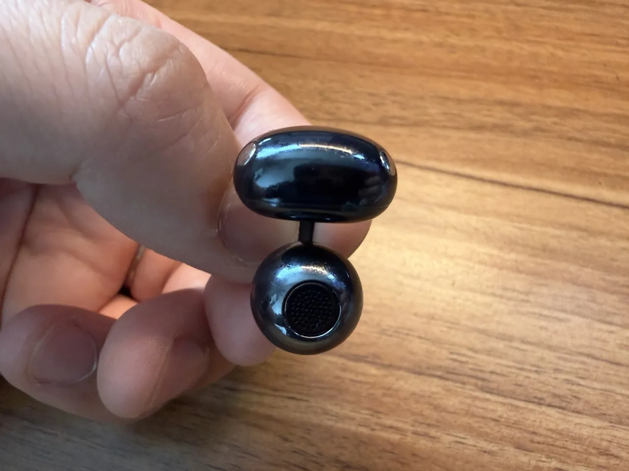 HUAWEI FreeClip 2のイヤホン単体を指で摘まんでいる(真下アングル)
