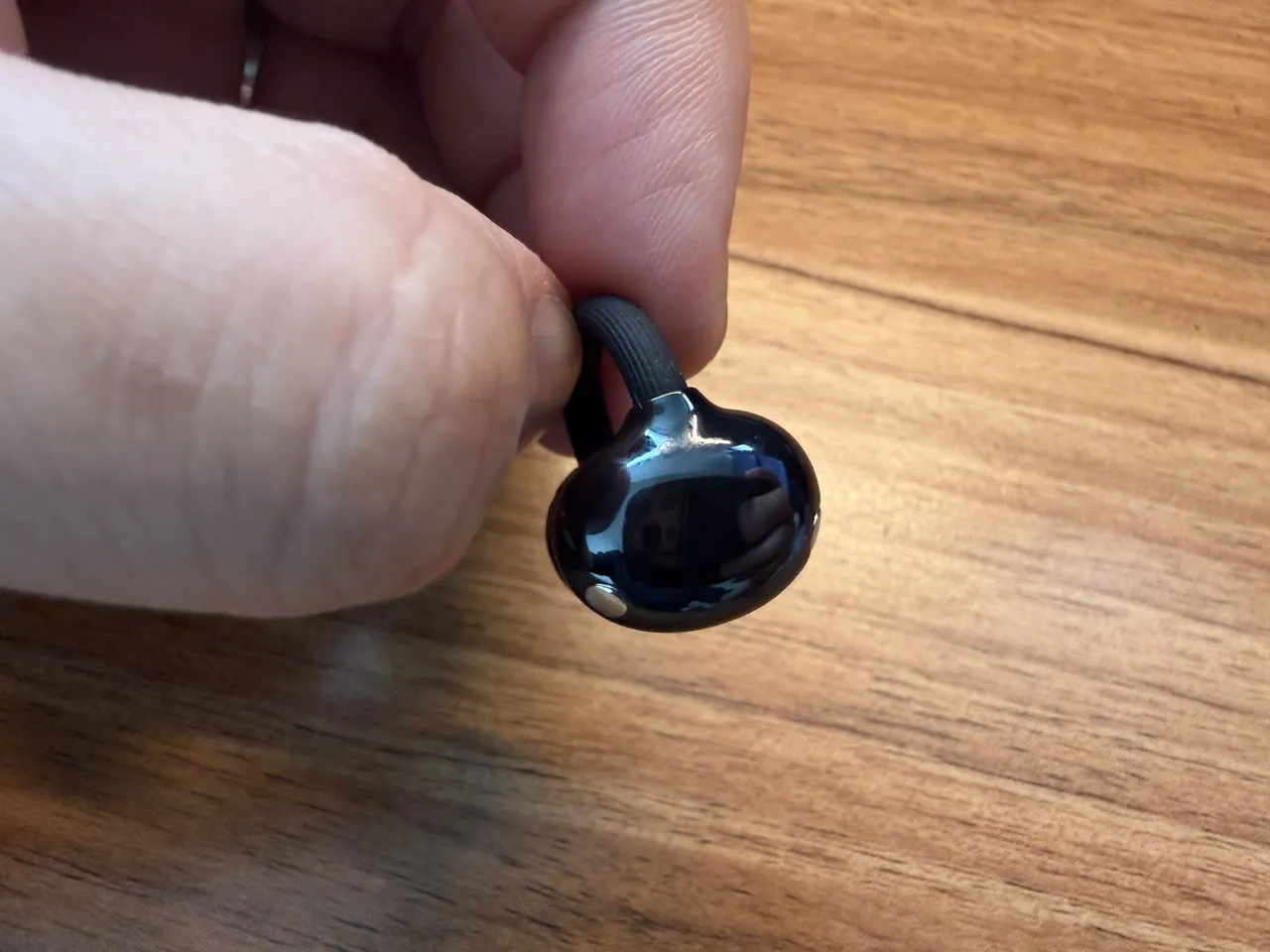 HUAWEI FreeClip 2のイヤホン単体を指で摘まんでいる(スワイプ機構)