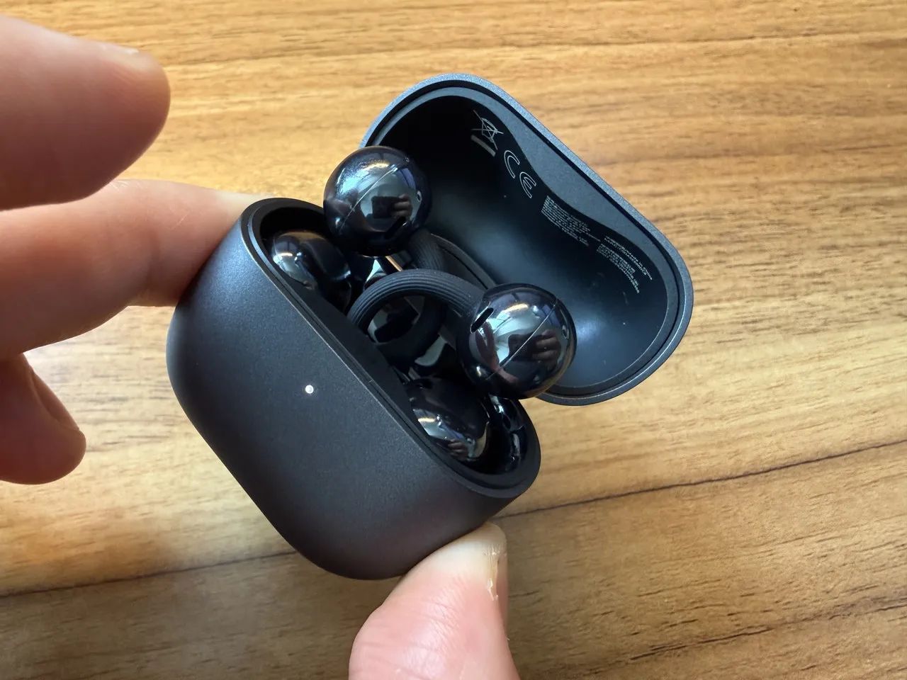 HUAWEI FreeClip 2の充電ケースのペアリングボタンを押している