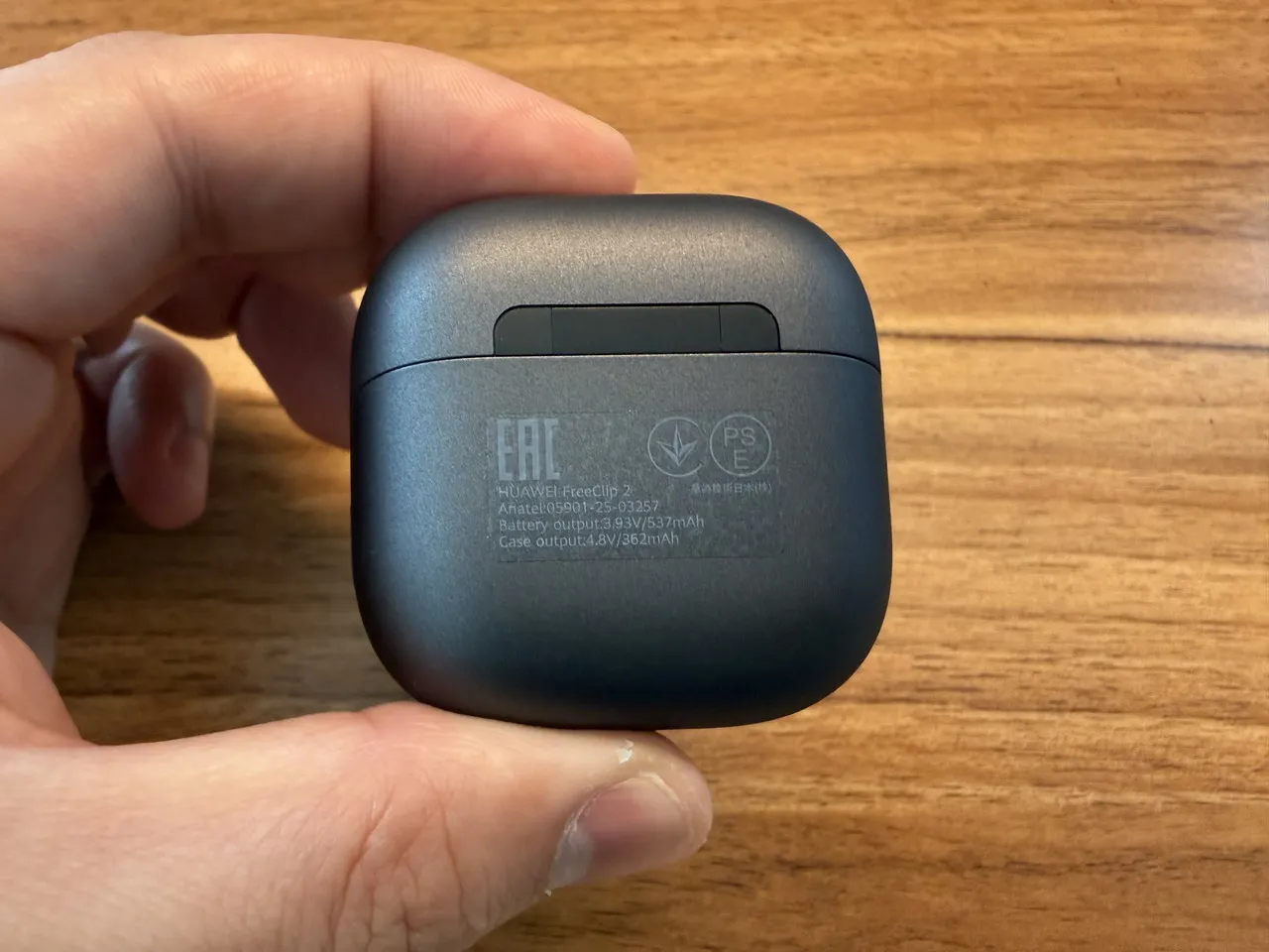 HUAWEI FreeClip 2の充電ケースを指で摘まんでいる