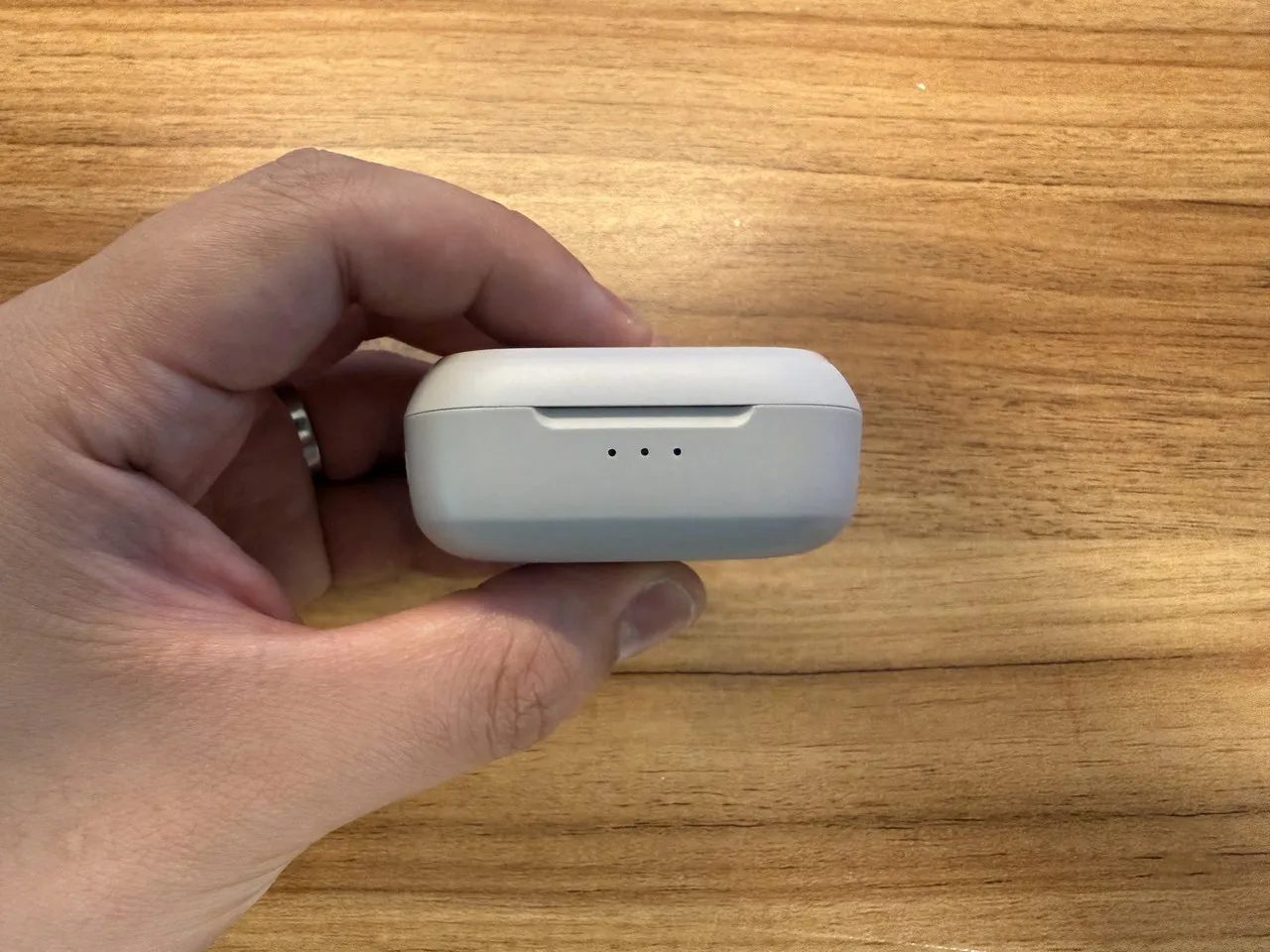 Cearvol Nanoの充電ケースを指で摘まんでいる(真横アングル)