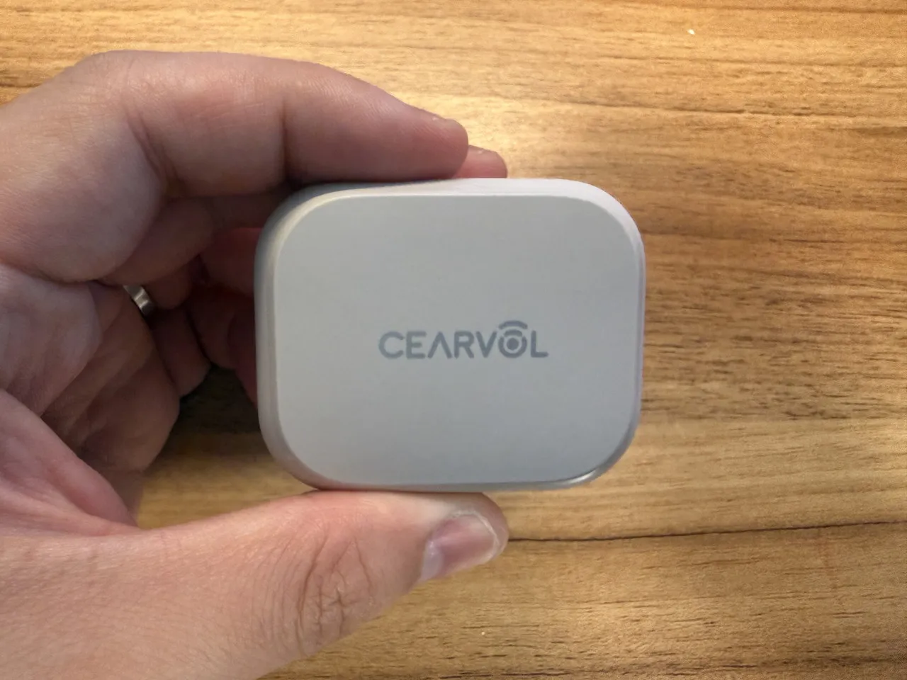 Cearvol Nanoの充電ケースを指で摘まんでいる(真上アングル)