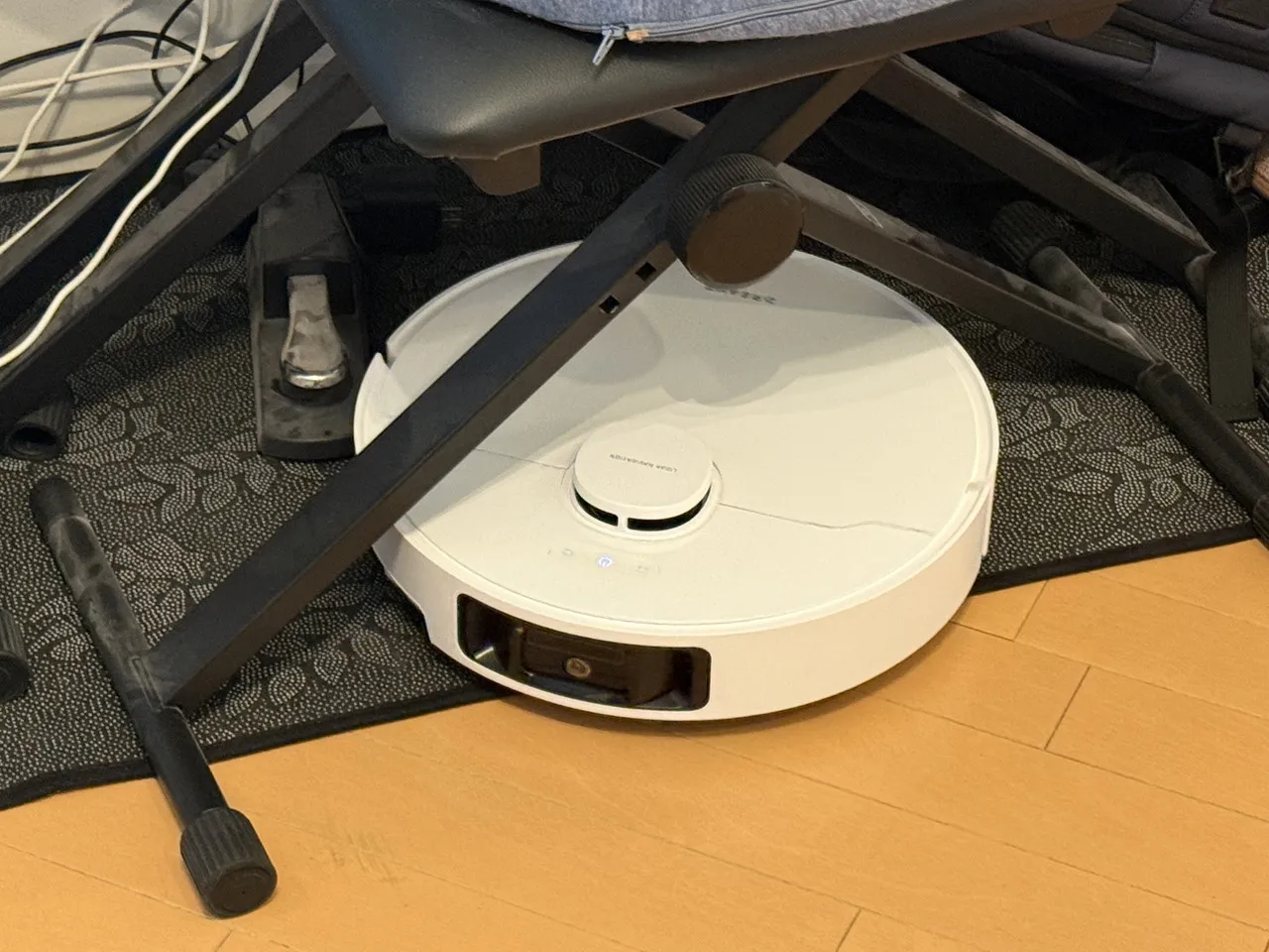 椅子の下を掃除しているロボット