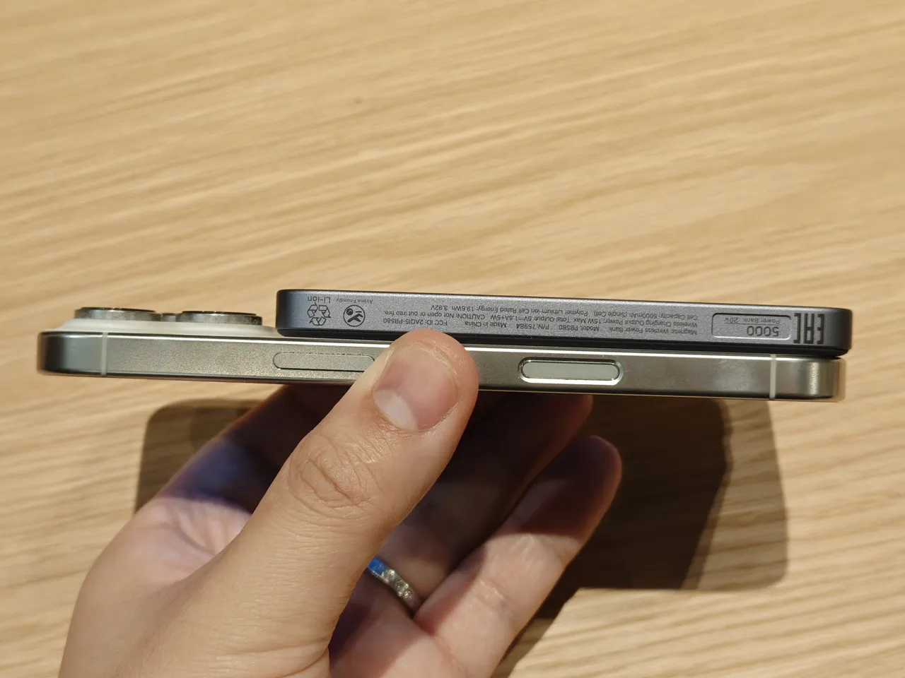 5000mAhモバイルバッテリーをiPhone背面に装着した状態で手に持っている