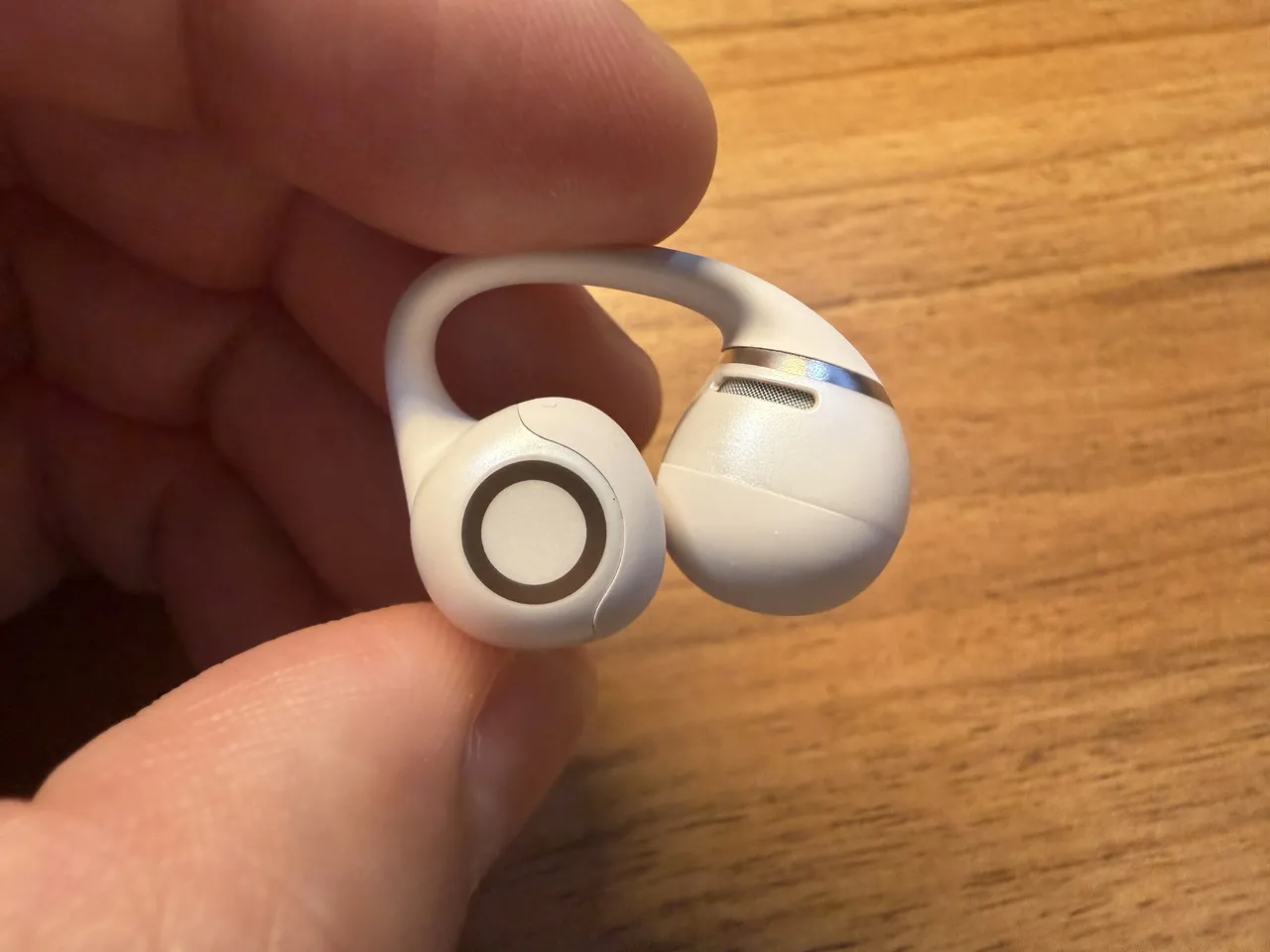 Shokz OpenDots 2のイヤホン本体を指で摘まんでいる(側面アングル)