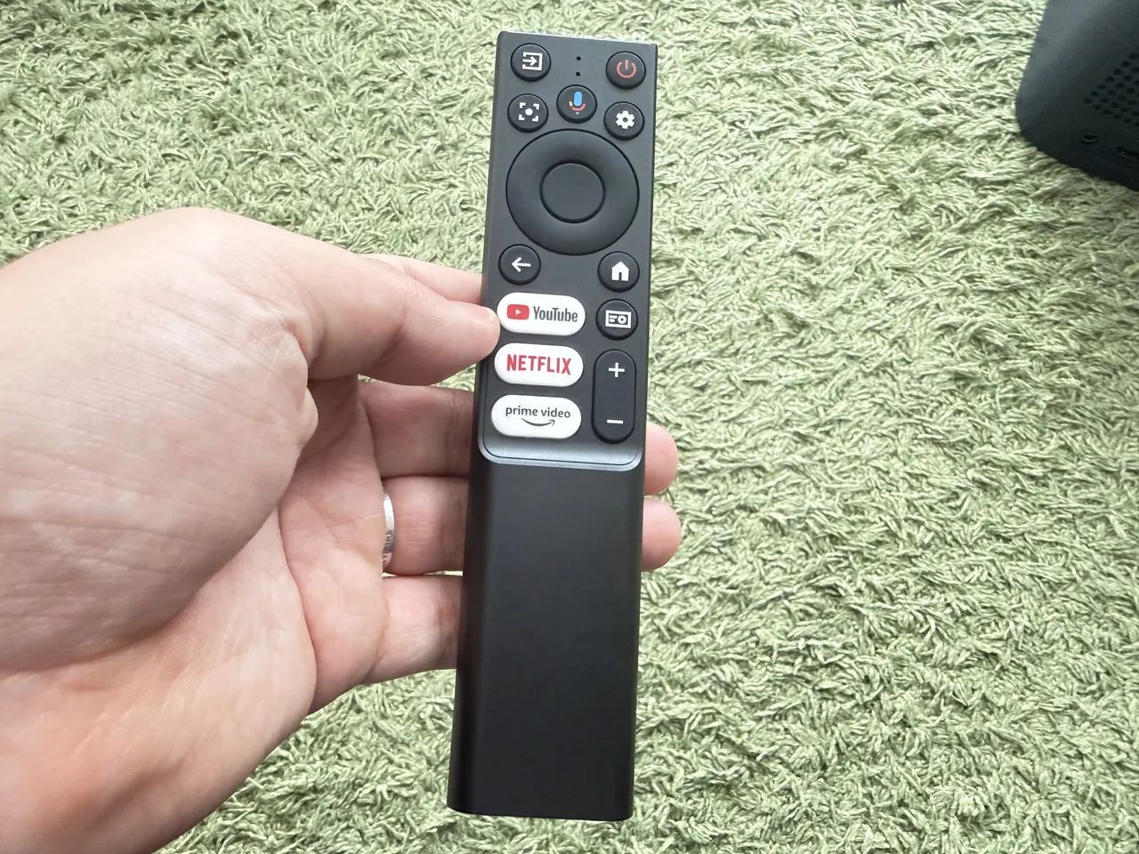 TCL A1sのリモコンを手に持っている