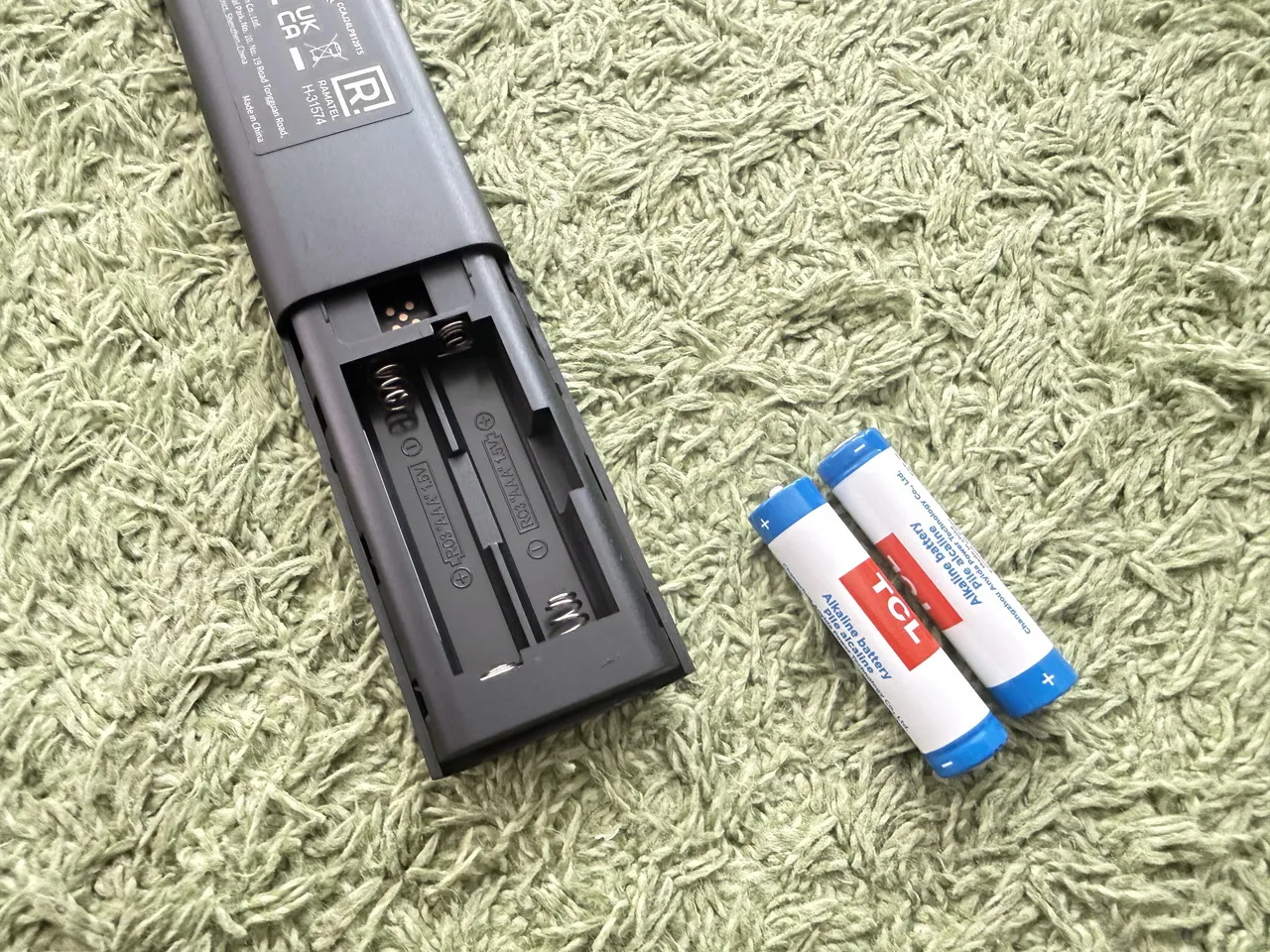 TCL A1sのリモコンに乾電池を入れている