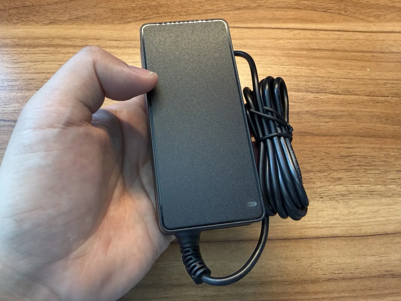 電源アダプタを手に持っている