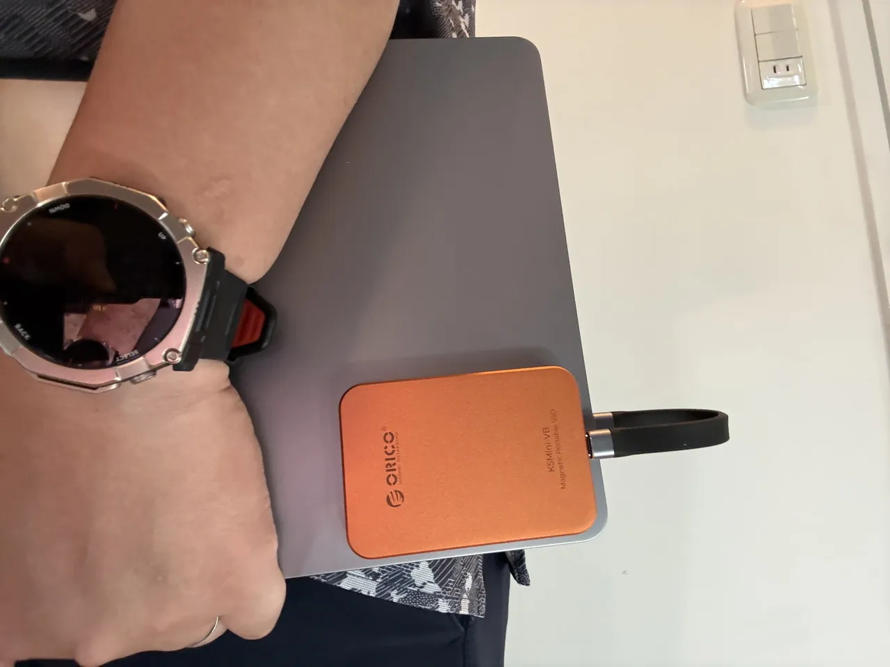Macbookの側面にORICO K5Miniを貼り付けている