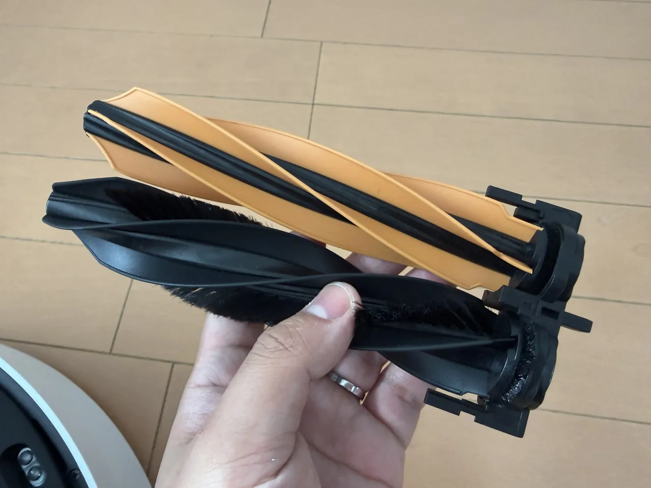 フローリング向けの毛付きラバーブラシと、カーペット向けのTPUゴム製ブラシを手に持っている