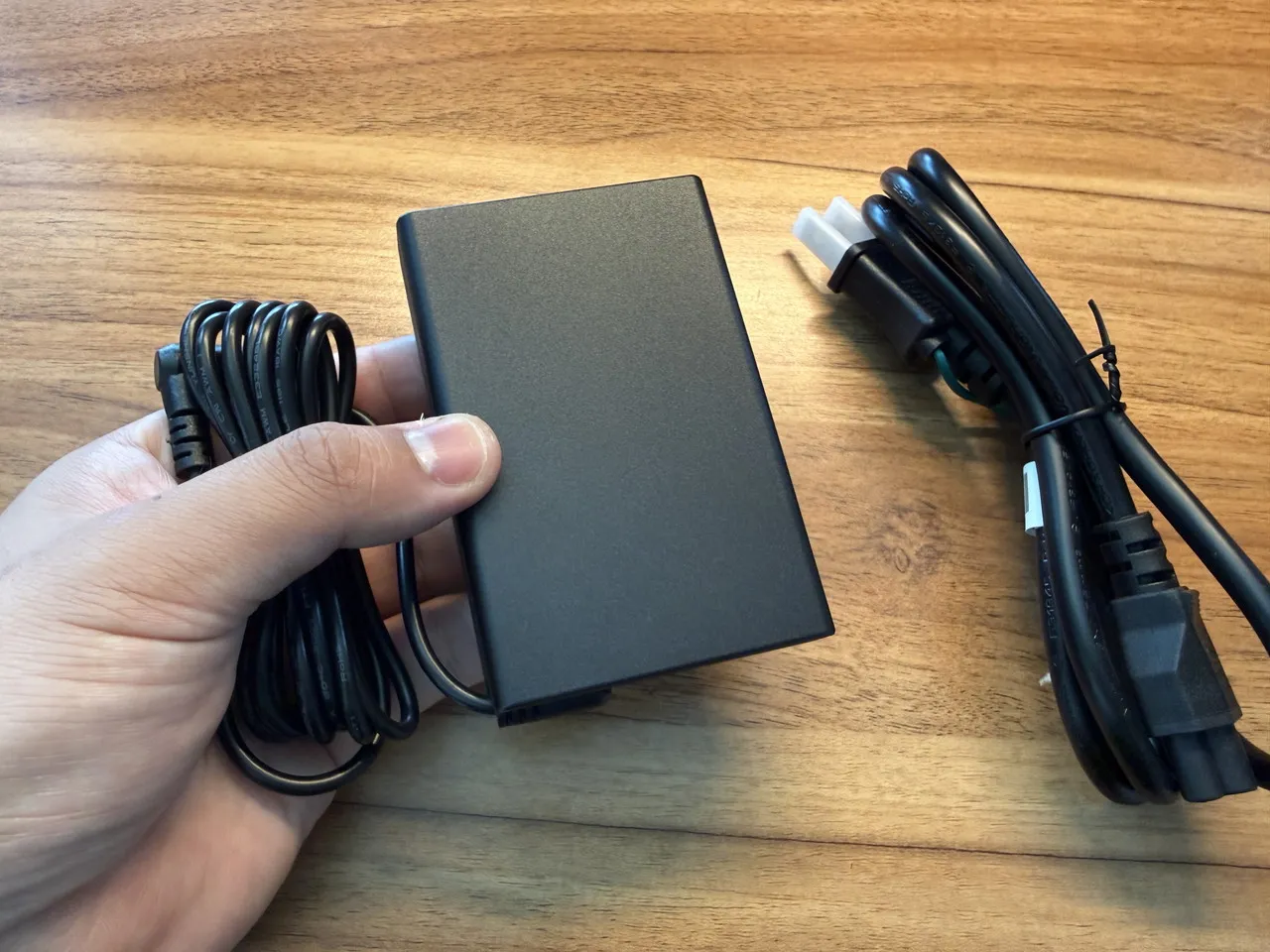 電源アダプタを手に持っている
