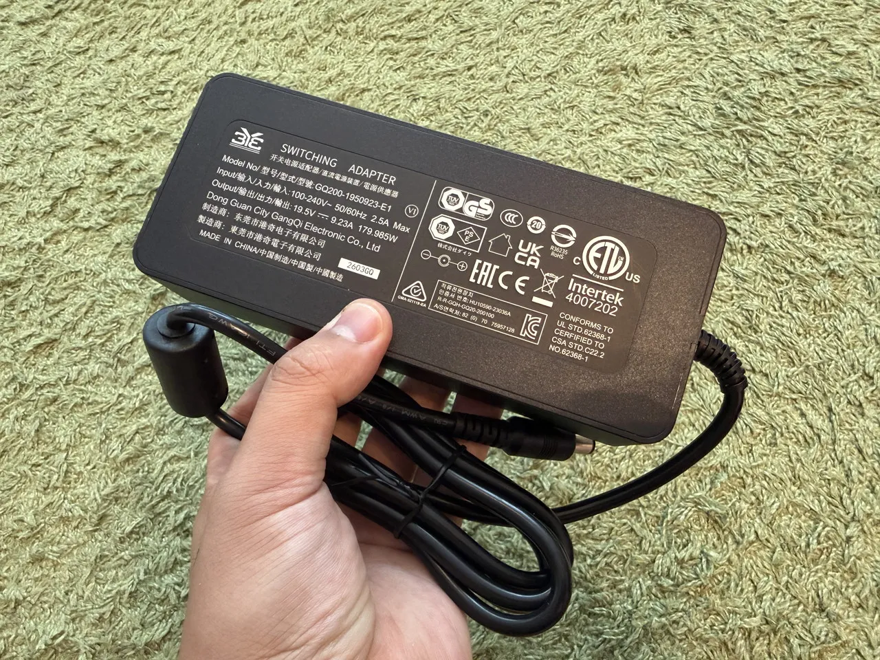 INNOCN CB27U1の電源アダプターを手に持っている