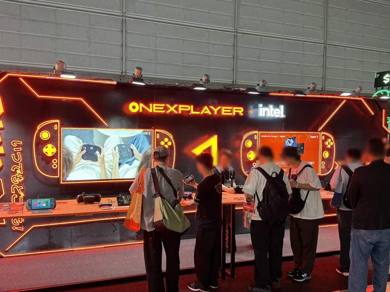 ONEXPLAYERとIntelのロゴを掲げたオレンジ色のゲーミング機器ブース
