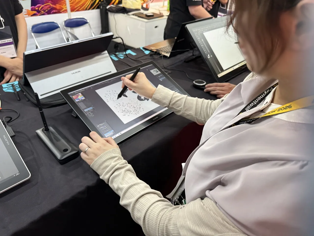 液晶ペンタブレットの画面にペンで描き、操作感を確かめる様子