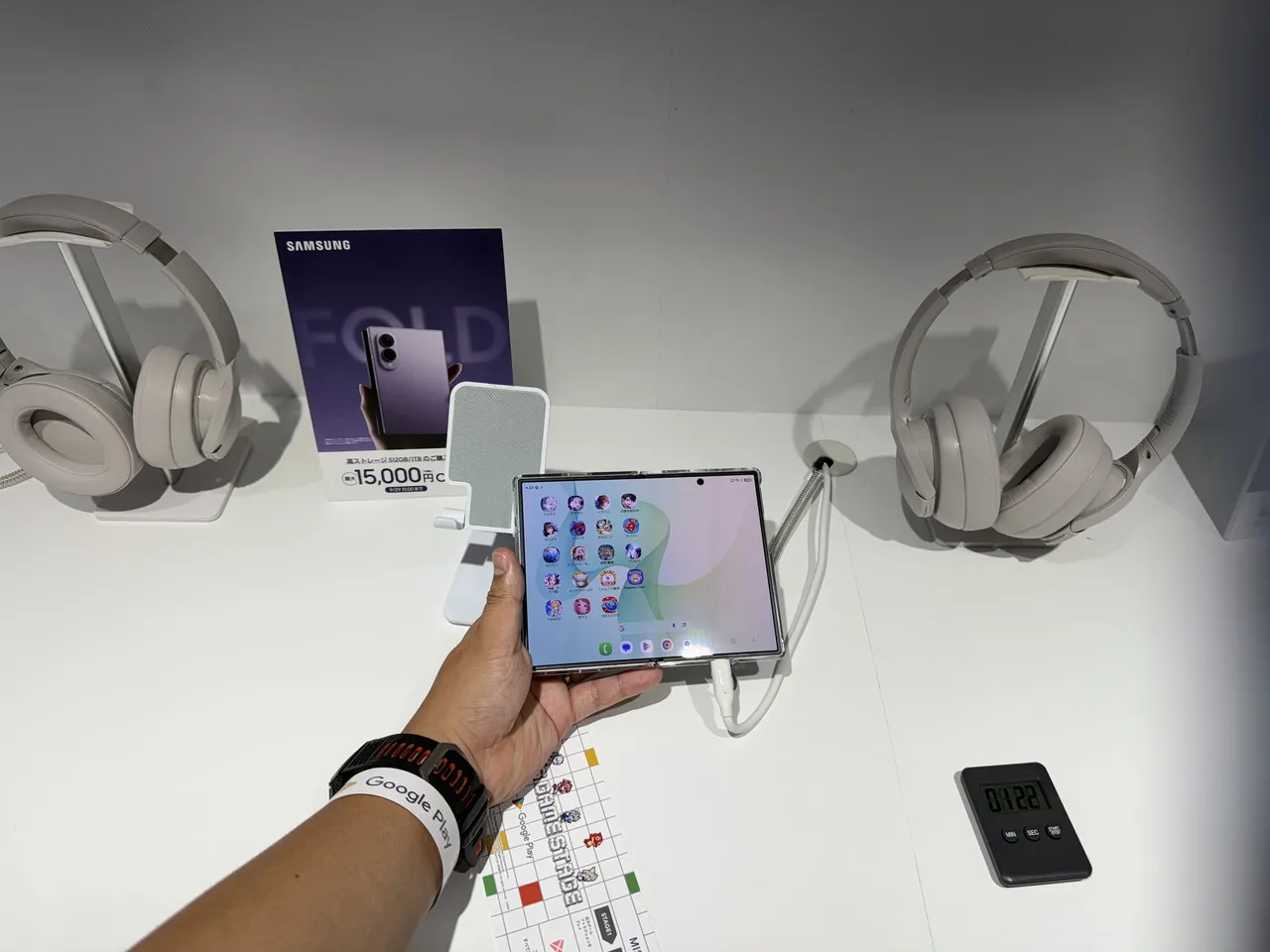 Google PlayブースのAndroid端末展示で折りたたみスマートフォンを手に取った様子