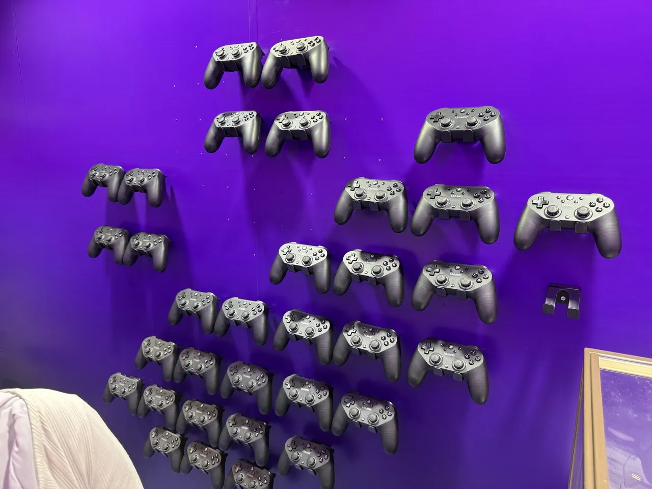 紫色の壁面に多数のゲームパッドが並べられたLeadJoyの展示