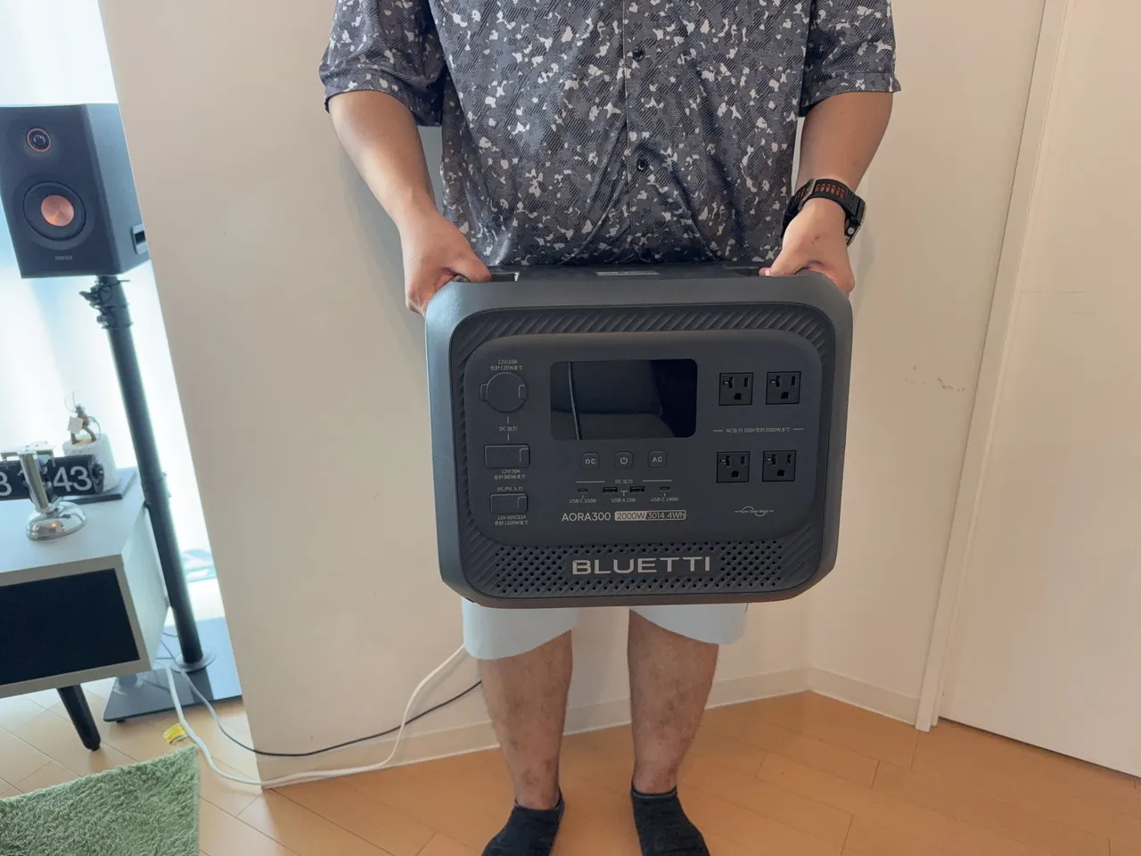 BLUETTI AORA 300を両手で持ち上げている