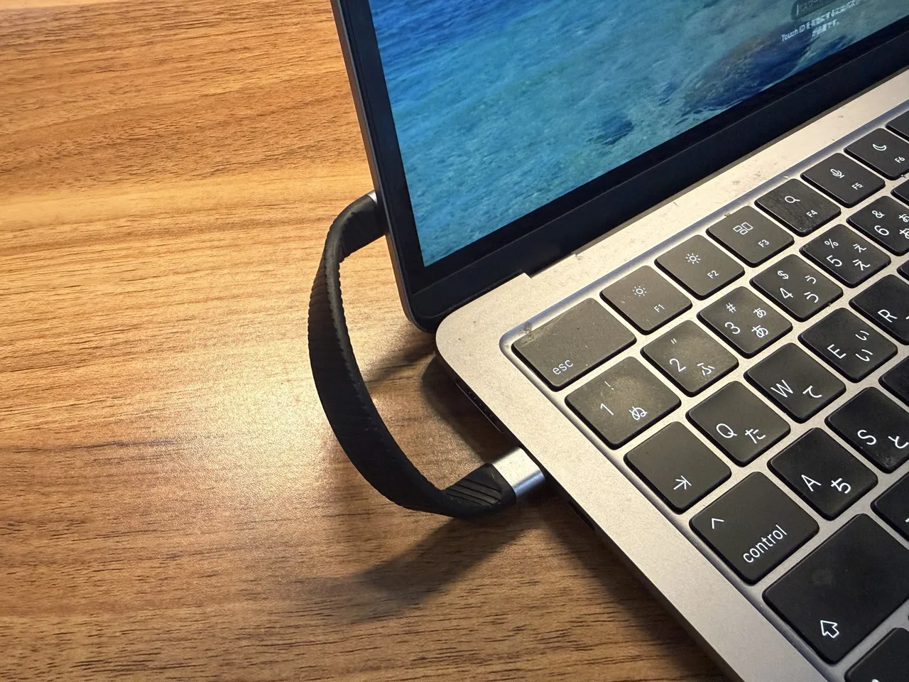 ORICO K20 Miniから伸びているケーブルがMacBook Airに接続されている(正面アングル)