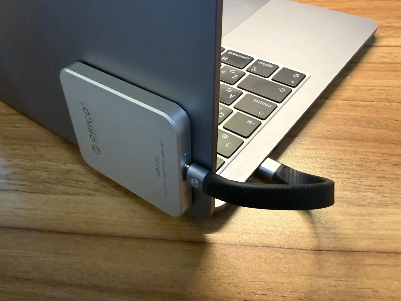 ORICO K20 Miniから伸びているケーブルがMacBook Airに接続されている(背面アングル)