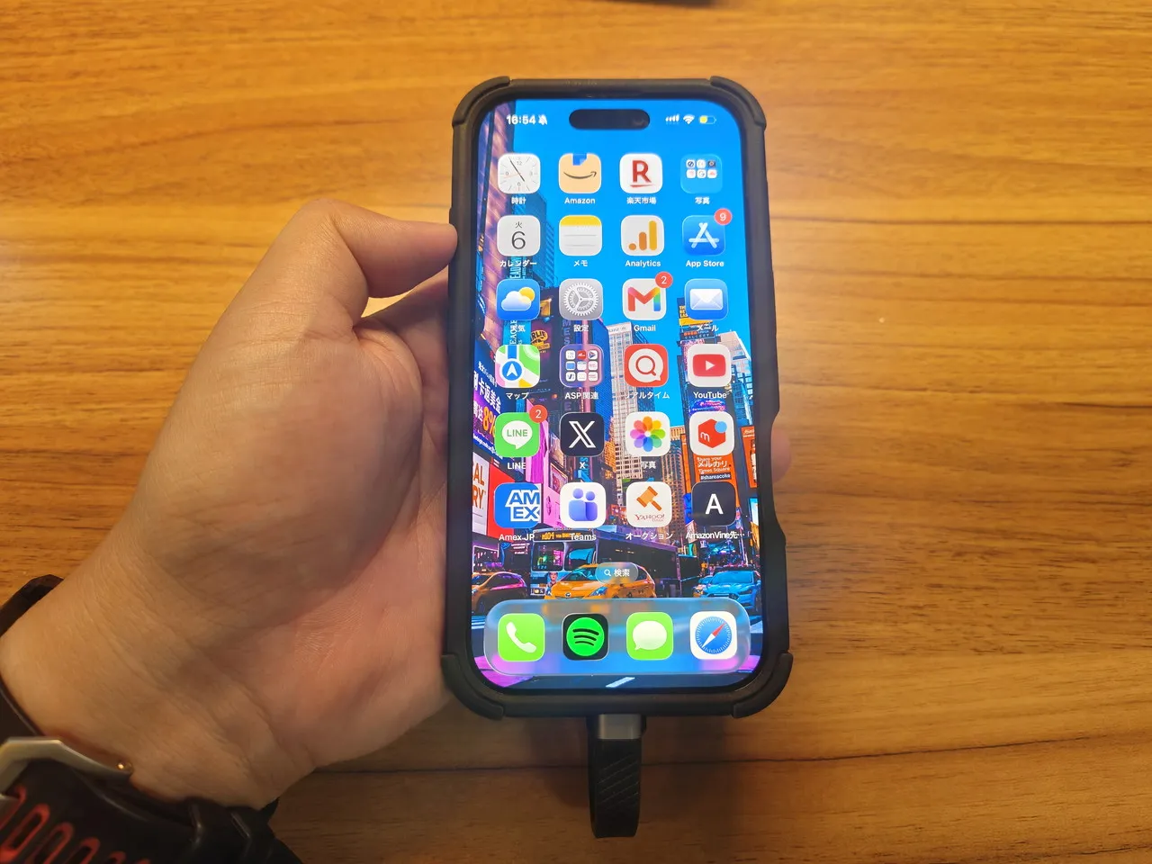 ORICO K20 Miniを装着したiPhone 16 Proを手に持っている(正面アングル)