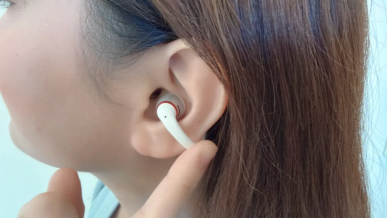 OpenDots 2 ディオモデルを装着した女性の左耳でタッチ操作している